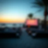 A stunning view of a beach cinema setup at dusk, with softly lit screens and cozy seating arrangements.
